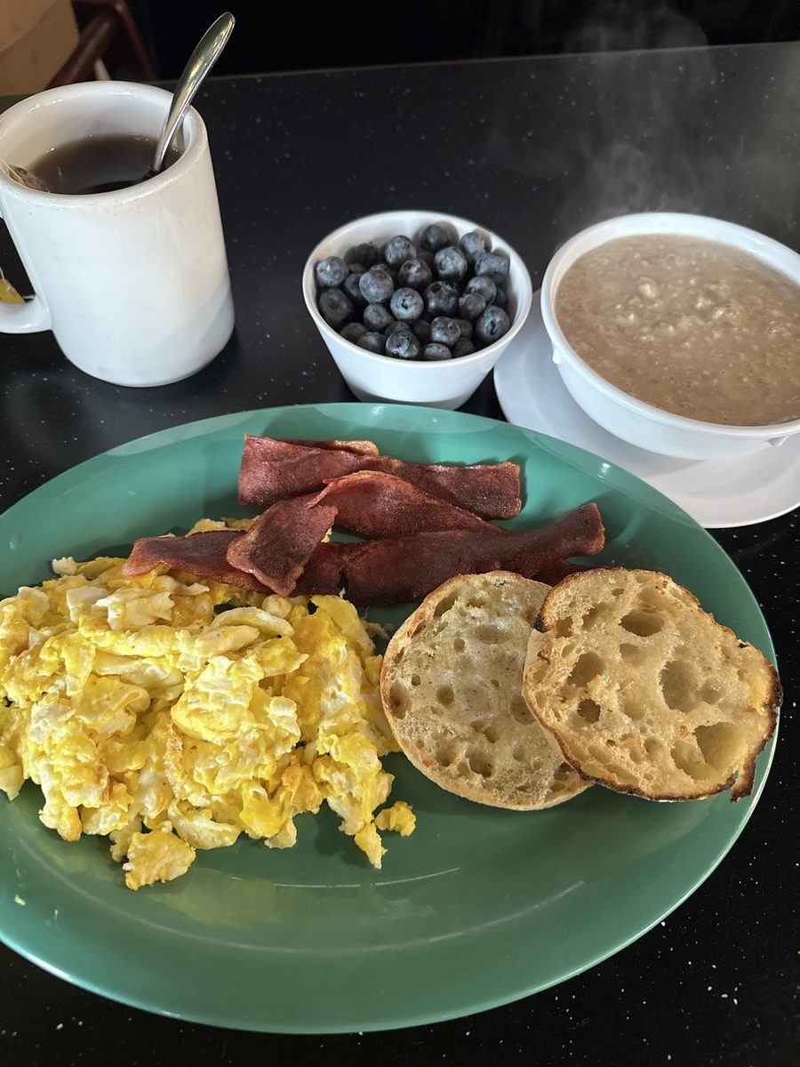 Scrambled eggs with turkey bacon, an english muffin, blueberries, and oatmeal